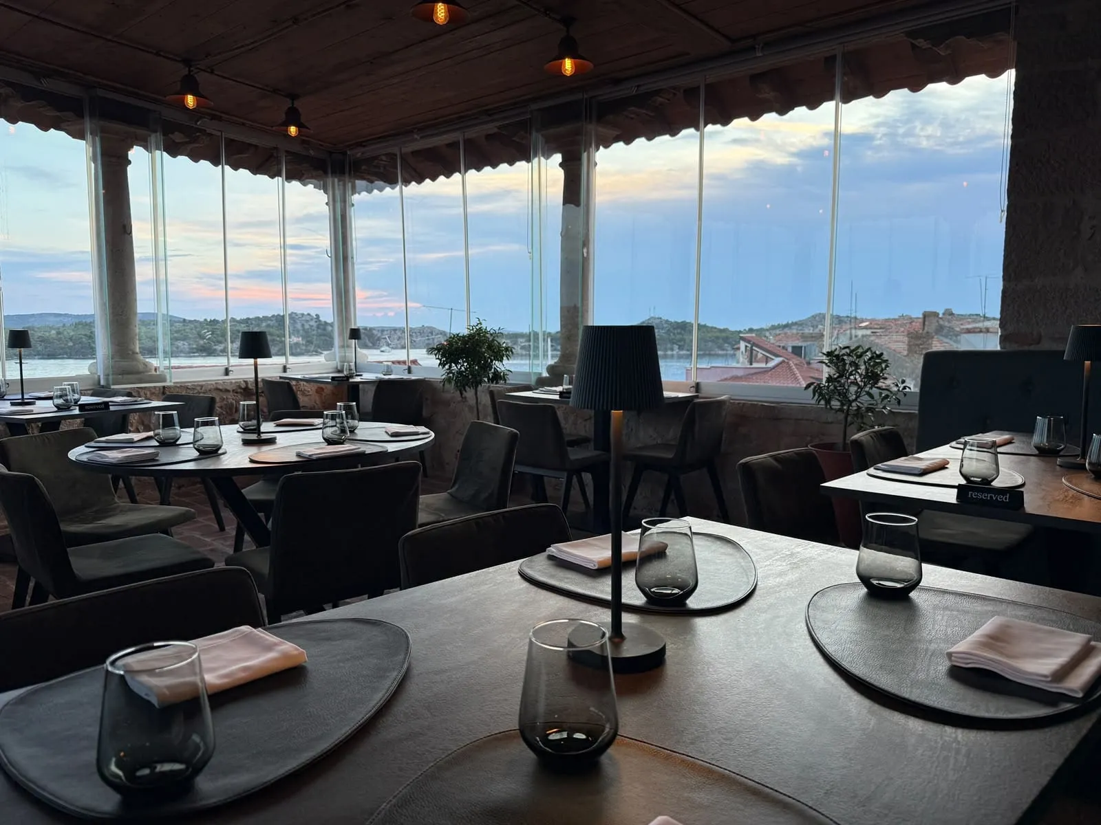 Terasa restorana sa stolovima uz stakleni zid